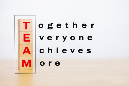 Motivation teamwork and team building concept. Wooden block stack up and word TEAM, Together, Everyone, Achieves, More on wooden table. With copy space for your text.